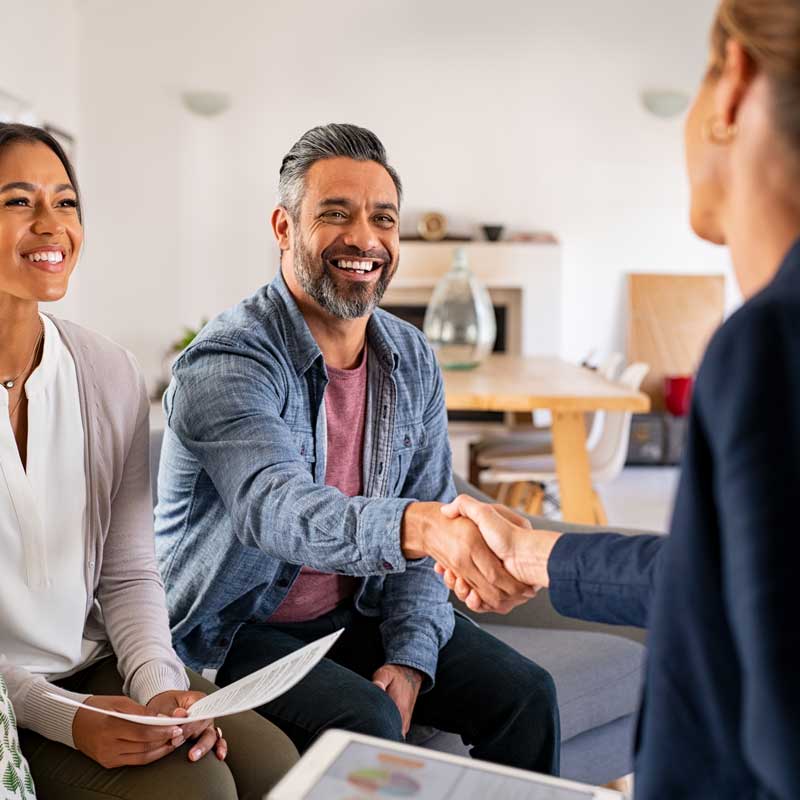 loans Mature indian man shaking hands with financial advisor at home.